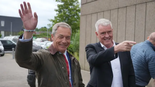 Reform UK leader Nigel Farage (left) and Reform UK parliamentary candidate Lee Anderson walking and smiling, with Farage waving