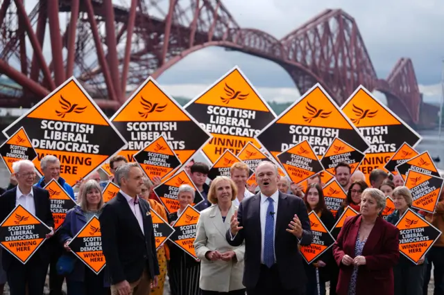 Liberal Democrat leader Sir Ed Davey stands with Alex Cole-Hamilton and activists