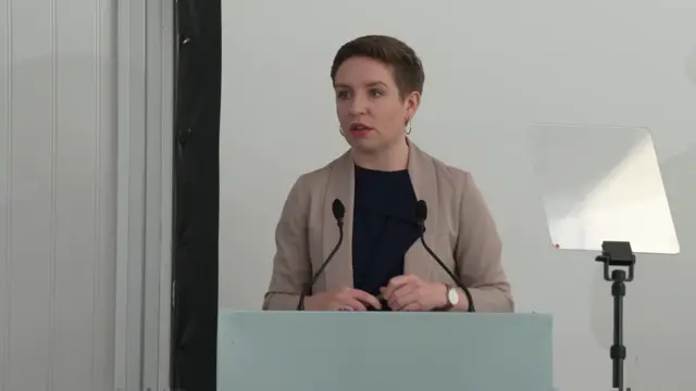 Carla Denyer stands at a podium while unveiling the Green Party manifesto.