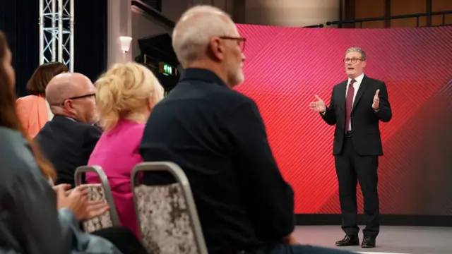 Sir Keir Starmer stands in front of an audience inside a Sky News studio