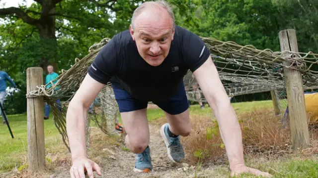 Liberal Democrats leader Sir Ed Davey on an assault course during a visit to Arena Pursuits in Wadhurst, Kent