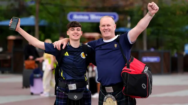 Scotland fans wearing klits pose for a picture after arriving at Munich airport