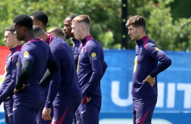 John Stones listens to coaching instructions behind team mates