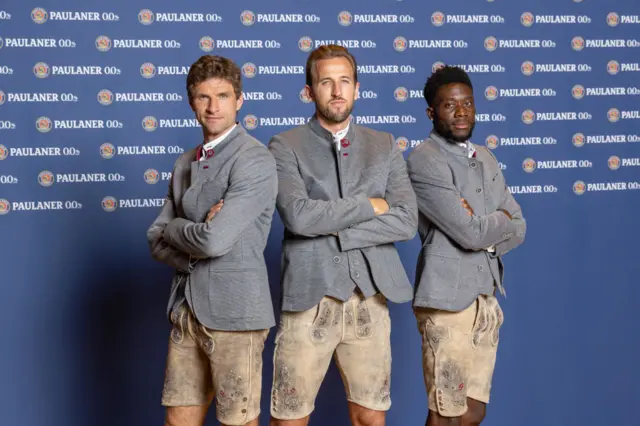 Thomas Muller, Harry Kane and Alphonso Davies of Bayern Munich wearing a traditional Bavarian outfit including lederhosen