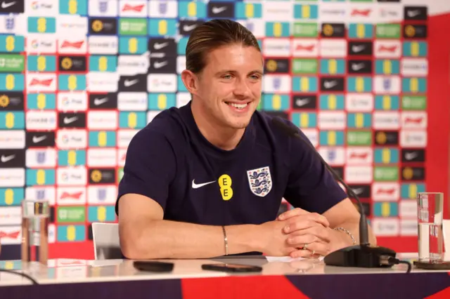 Conor Gallagher cracks a smile while listening to questions from the media