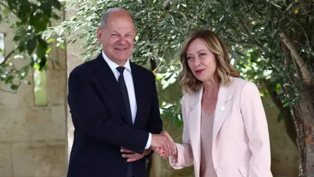 Olaf Scholz shaking hands with Giorgia Meloni