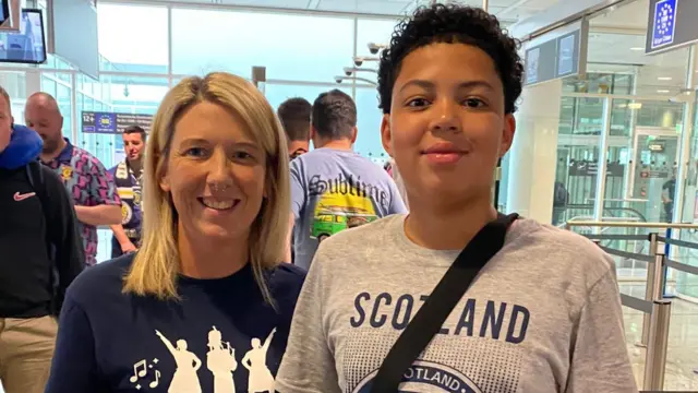 Mother and son Mary-Anne and John in passport control, about to fly to Germany to see Scotland play at Euro 2024