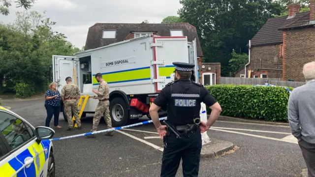 Police man standing in front of bomb disposal vehicle