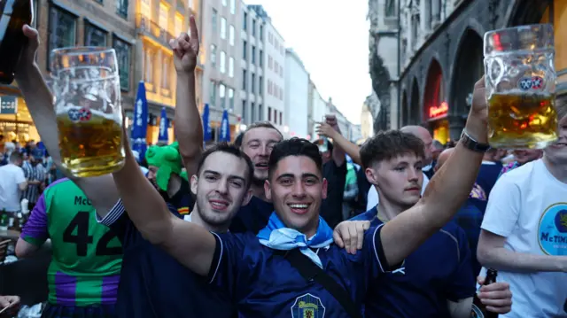 Scotland fans holding up beers in Munich before the national team's game against Germany in Euro 2024