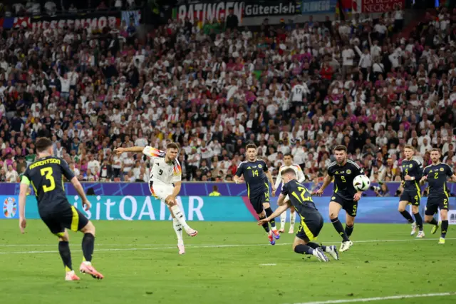 Niclas Fuellkrug of Germany scores his team's fourth goal whilst under pressure from Kenneth McLean of Scotland during the UEFA EURO 2024 group stage match between Germany and Scotland at Munich Football Arena