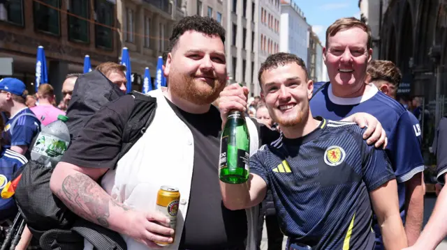 Craig Ferguson shares a drink with a fellow Scotland fan after walking to Munich before their Euro 2024 game against Germany