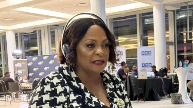 Nomvula Mokonyane sits with headphones on