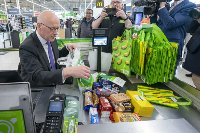 Swinney bags groceries at a supermarket till