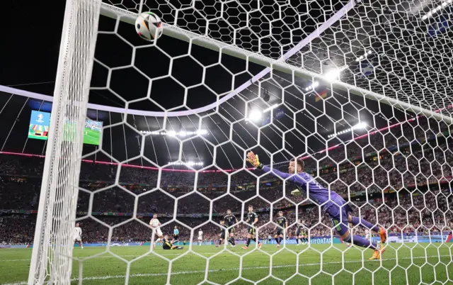 Niclas Fuellkrug of Germany scores his team's fourth goal whilst under pressure from Kenneth McLean of Scotland during the UEFA EURO 2024 group stage match between Germany and Scotland at Munich Football Arena