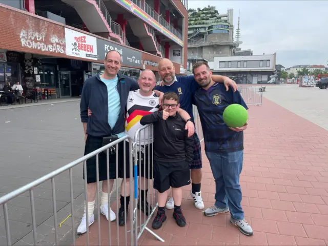 Football fans posing for a picture outside the St Pauli stadium in Hamburg