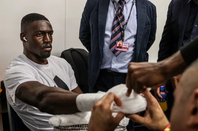 Richard Riakporhe has his hands wrapped before a fight backstage