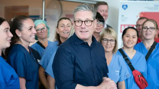 Starmer surrounded by a group of medical staff