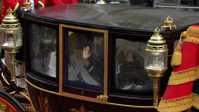 Catherine and Princess Charlotte wipe the windows of their carriage as it rains.