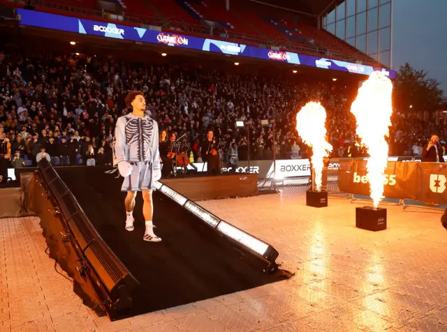 Ben Whittaker walks past flames on his way to the ring