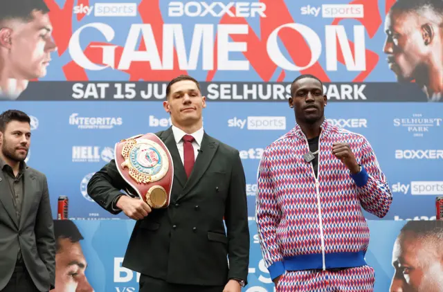 Chris Billam-Smith holds the WBO cruiserweight title over his shoulder as he stands next to Richard Riakporhe