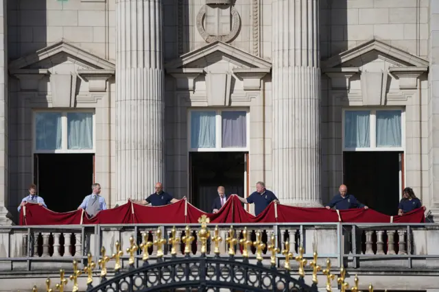 Royal staff pictured on the balcony at Buckingham Palace