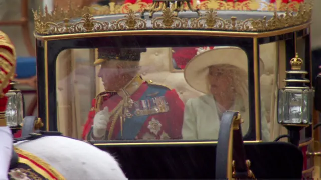 King and Queen seen in their carriage as they make their way back to Buckingham Palace.