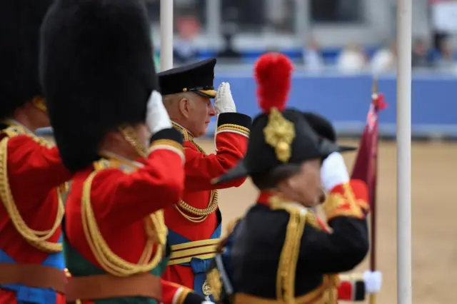 King Charles at the forefront of a group saluting the troops