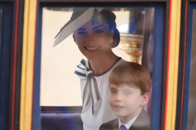 The Princess of Wales sits behind her son Prince Louis in a glass coach