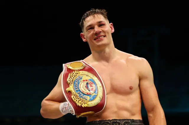 Chris Billam-Smith smiles with his world title around his shoulder