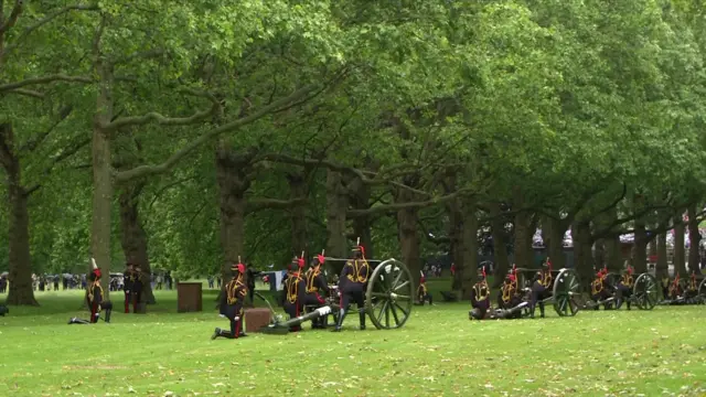 The gun salute at Green Park, soldiers stand in regalia.