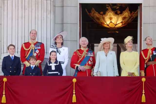 Members of the Royal Family look up to the sky from the balcony at Buckingham Palace