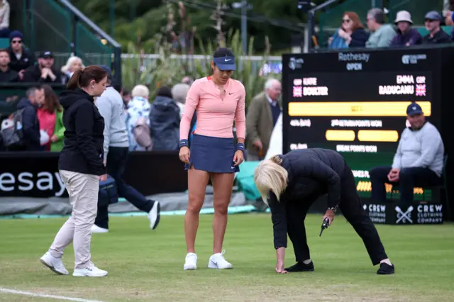 Emma Raducanu and tournament officials examine the court