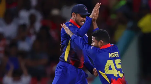 Dipendra Singh Airee of Nepal celebrates with teammate Sandeep Lamichhane after dismissing Najmul Hossain Shanto of Bangladesh (not pictured) during the ICC Men's T20 Cricket World Cup West Indies & USA 2024 match