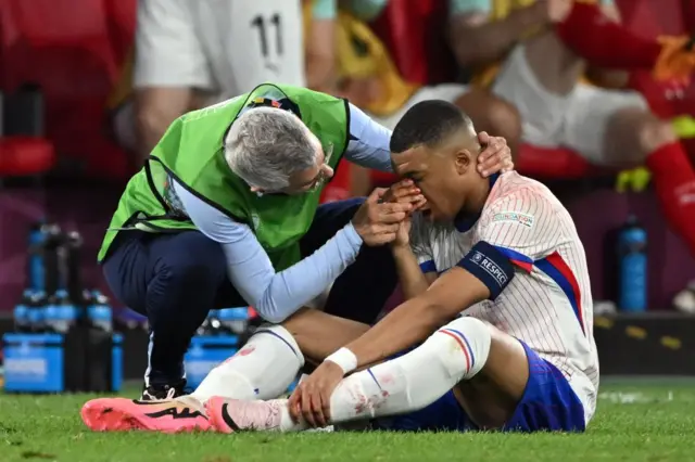 Kylian Mbappe being helped by the France physio