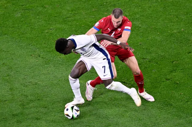 Bukayo Saka fights for the ball