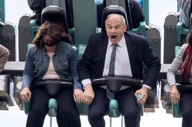 Sir Ed Davey open mouthed riding a rollercoaster