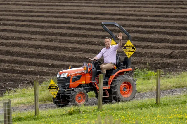 Cole-Hamilton waves as he rides a red tractor