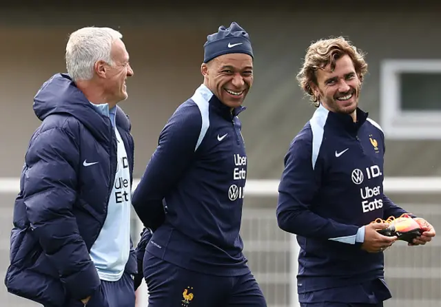 Didier Deschamps (L) looks at France's forward Kylian Mbappe (C), flanked by France's forward Antoine Griezmann