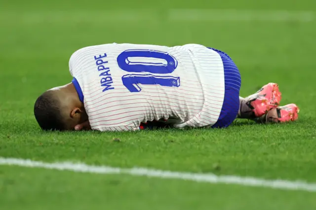 Kylian Mbappe laying on the ground