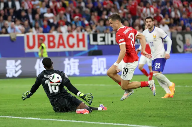 Mike Maignan of France saves a shot from Christoph Baumgartner