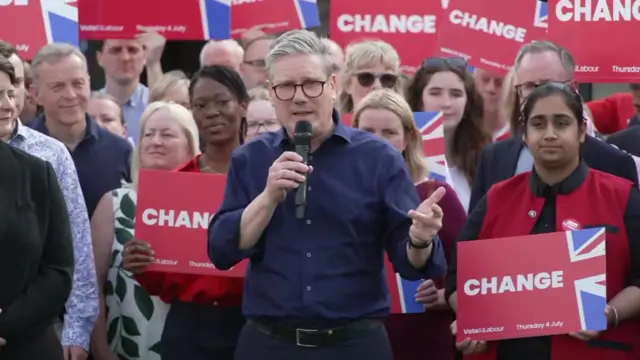 Keir Starmer speaks to supporters who hold up Labour signs behind him