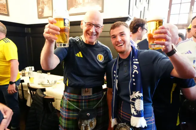 Scotland fan Craig Ferguson (right), who has walked from Scotland to Germany for Euro 2024 with First Minister of Scotland John Swinney at Marienplatz square, Munich