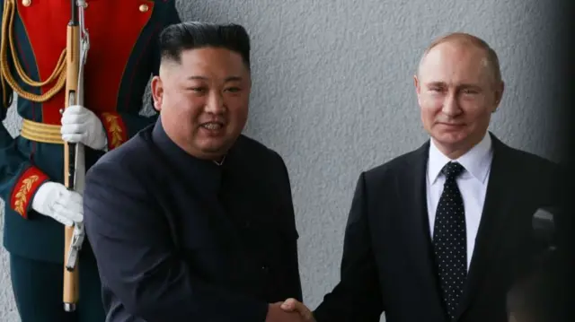 Kim Jong Un, North Korea's leader, left, shakes hands with Vladimir Putin