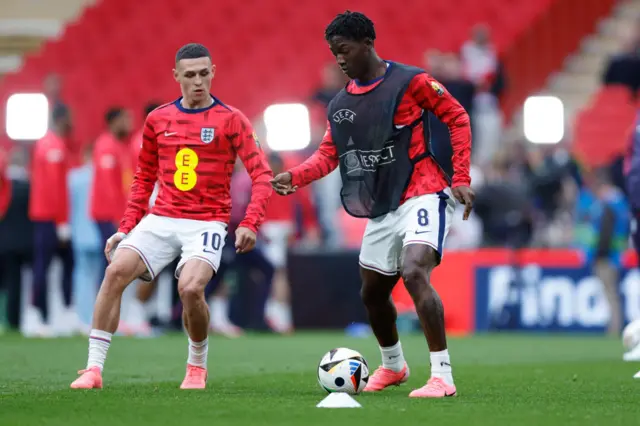 Phil Foden and Kobbie Mainoo warm-up