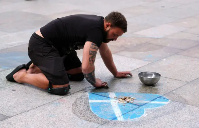 A Scotland fan draws a Scottish saltire love heart outside Cologne Cathedral.