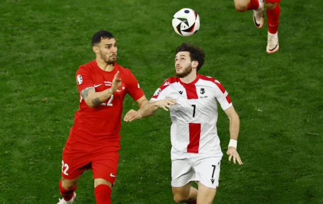 Turkey's Kaan Ayhan in action with Georgia's Khvicha Kvaratskhelia