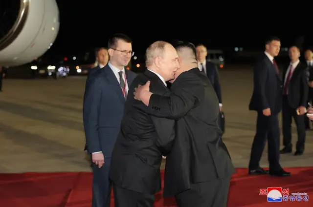 Vladimir Putin and Kim Jong Un embrace on the tarmac