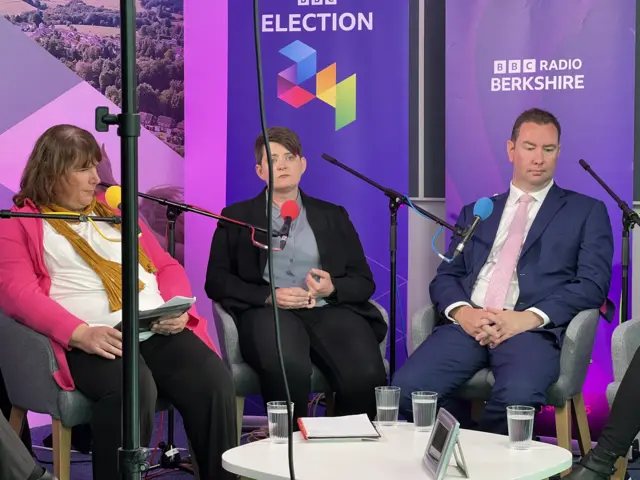 Three sat around a table candidates listening to the questions being put to them