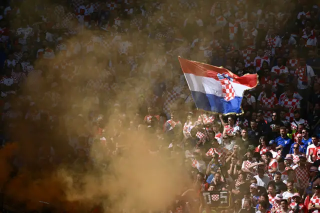 Croatia fans light flares and wave flags