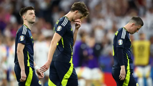 Dejected Scotland players walk off the field after the loss to Germany